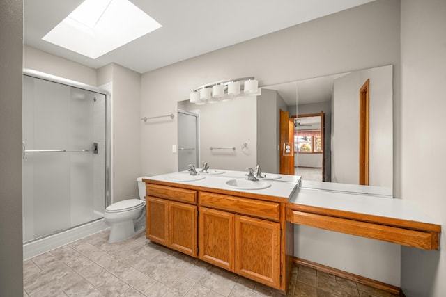 full bath featuring a sink, double vanity, a shower stall, and toilet