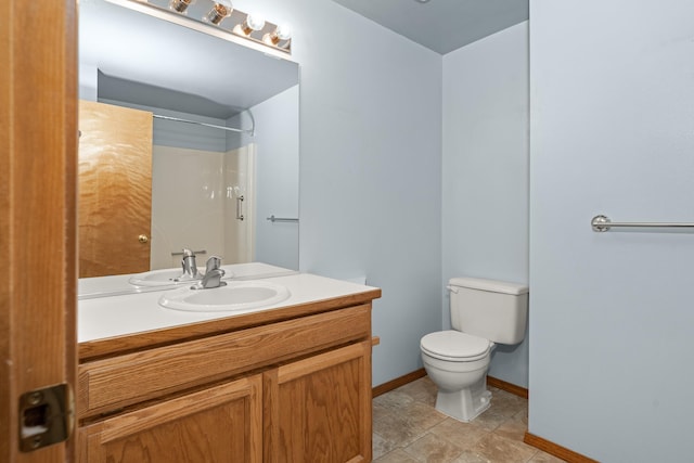 full bath with toilet, baseboards, a shower, and vanity