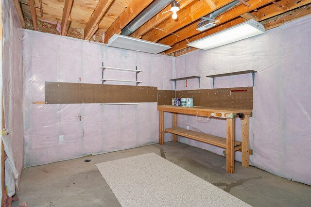 unfinished basement featuring a workshop area