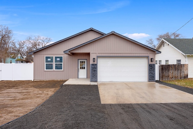 view of front of home with a garage, driveway, and fence