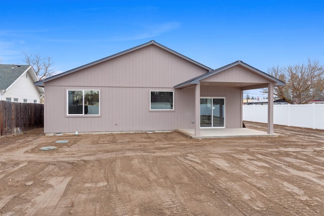 rear view of house with a fenced backyard and a patio