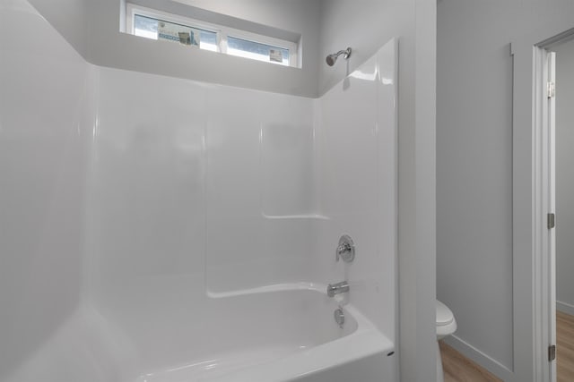 bathroom featuring  shower combination, wood finished floors, and toilet