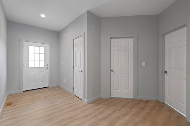 foyer entrance featuring light wood-style floors, baseboards, and visible vents