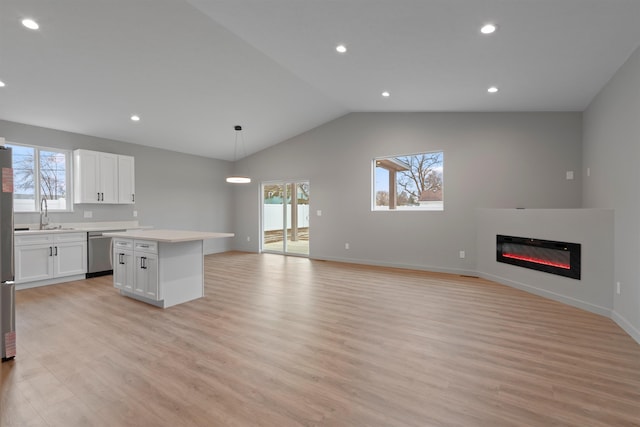 kitchen featuring open floor plan, appliances with stainless steel finishes, plenty of natural light, and a kitchen island