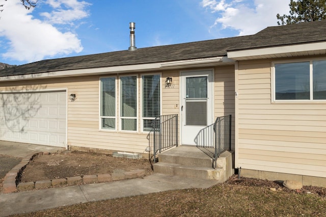 view of front of home featuring a garage and roof with shingles