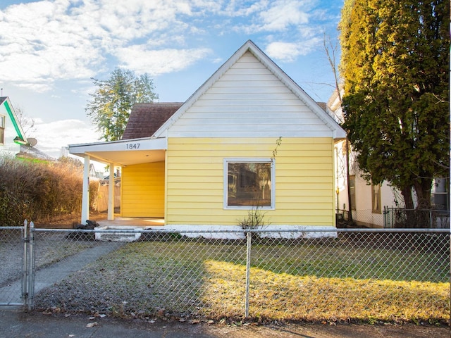 view of front of home featuring an attached carport, a fenced front yard, and a front yard