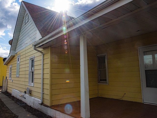 view of side of property with roof with shingles