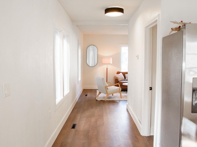 corridor with visible vents, baseboards, and wood finished floors