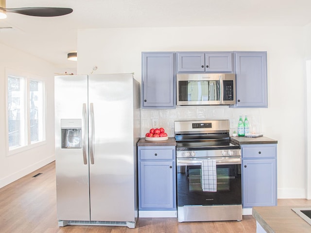 kitchen featuring tasteful backsplash, visible vents, appliances with stainless steel finishes, gray cabinetry, and light wood-style floors