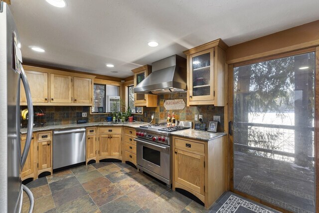 kitchen featuring wall chimney range hood, tasteful backsplash, stainless steel appliances, and recessed lighting