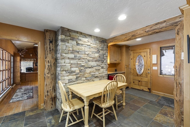 dining space featuring a textured ceiling, recessed lighting, baseboards, and stone tile floors