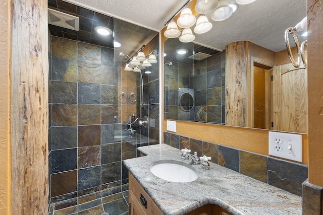 full bathroom featuring vanity, a textured ceiling, and a walk in shower