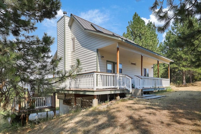 view of front of property with metal roof and a chimney