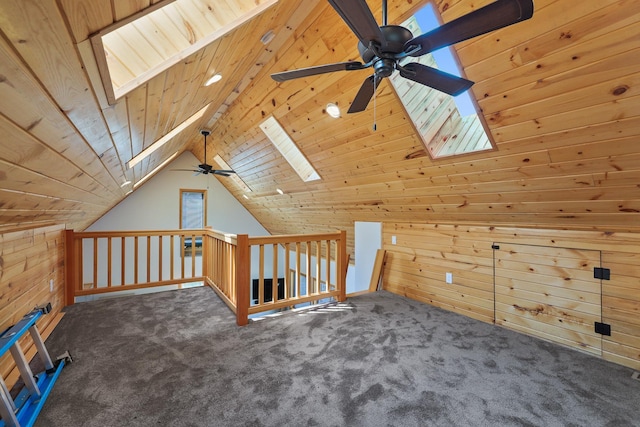 additional living space with lofted ceiling with skylight, wood walls, and carpet