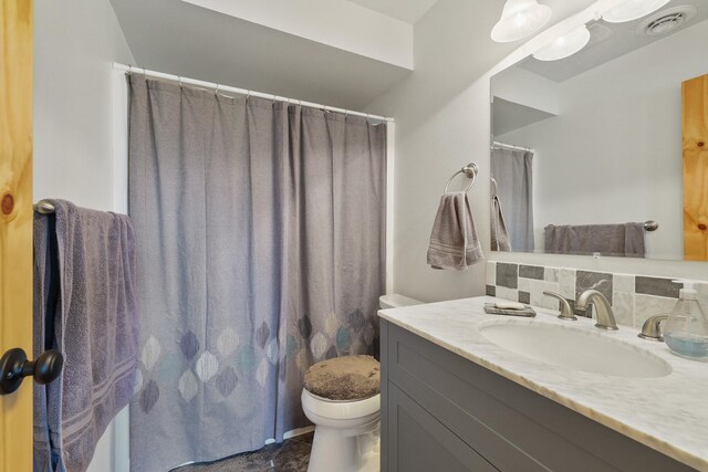 full bathroom with toilet, tasteful backsplash, visible vents, and vanity