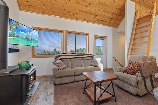 living room with baseboards, lofted ceiling, wood ceiling, wood finished floors, and a wood stove