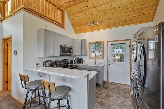 6152 Winding River Way, Fruitland, WA 99129 - kitchen featuring appliances with stainless steel finishes, gray cabinets, wood ceiling, a peninsula, and a kitchen breakfast bar