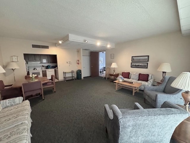 living room featuring visible vents, a textured ceiling, and dark colored carpet