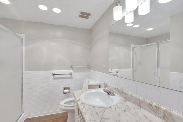 1311 S Westcliff Pl Unit 509, Spokane, WA 99224 - bathroom featuring toilet, a stall shower, tile walls, vanity, and a wainscoted wall