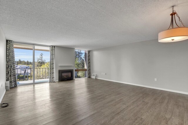 1311 S Westcliff Pl Unit 509, Spokane, WA 99224 - unfurnished living room with dark wood-style flooring, a textured ceiling, floor to ceiling windows, a fireplace, and baseboards