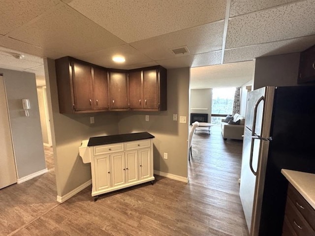 kitchen with visible vents, light wood finished floors, baseboards, freestanding refrigerator, and open floor plan