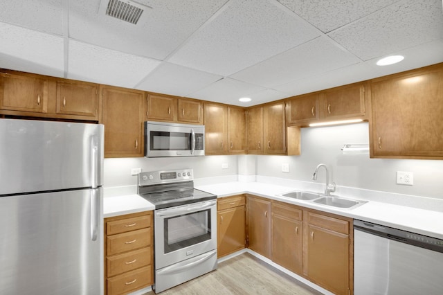 1311 S Westcliff Pl Unit 509, Spokane, WA 99224 - kitchen with appliances with stainless steel finishes, a sink, light countertops, light wood finished floors, and a paneled ceiling