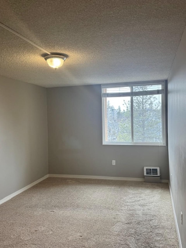 empty room featuring carpet flooring, baseboards, visible vents, and a textured ceiling