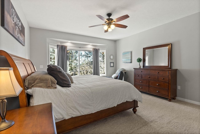 carpeted bedroom with ceiling fan and baseboards