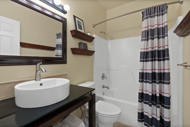 bathroom featuring toilet, shower / tub combo, and vanity