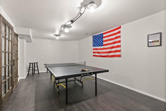 playroom with baseboards and dark wood-type flooring