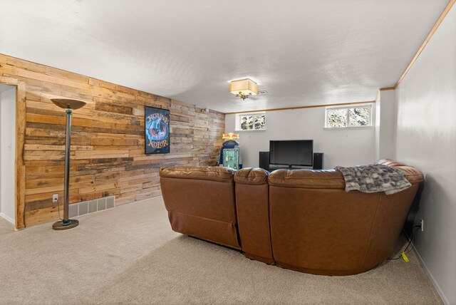 carpeted living room with baseboards, visible vents, and wooden walls