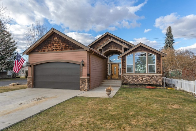 view of front of house featuring a garage, fence, concrete driveway, stone siding, and a front yard