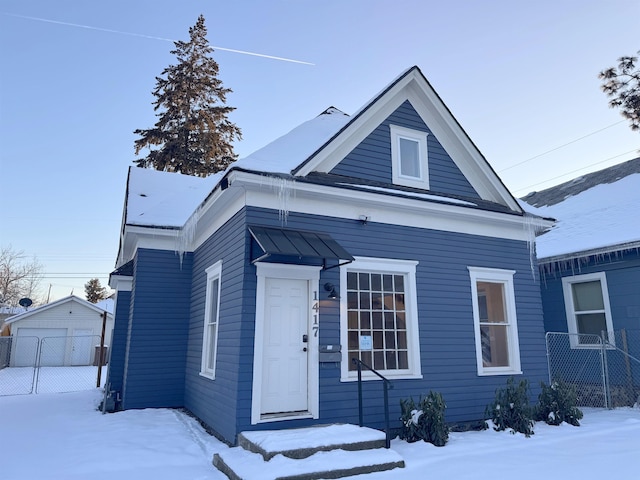 view of front of house with a detached garage and fence