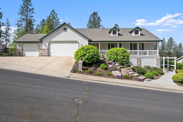 view of front facade featuring a shingled roof, covered porch, driveway, and an attached garage