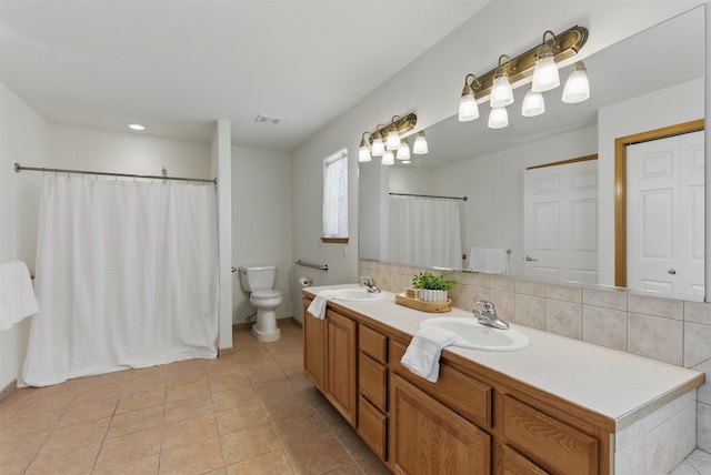 full bathroom featuring toilet, a sink, visible vents, double vanity, and tasteful backsplash