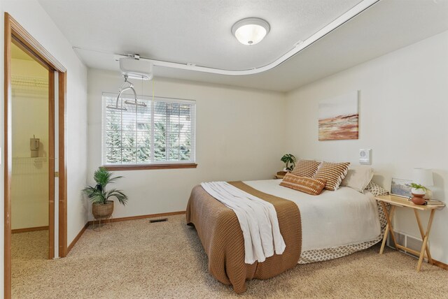 carpeted bedroom with baseboards and visible vents