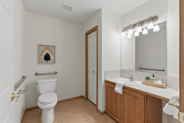 bathroom featuring tile patterned flooring, toilet, vanity, visible vents, and baseboards