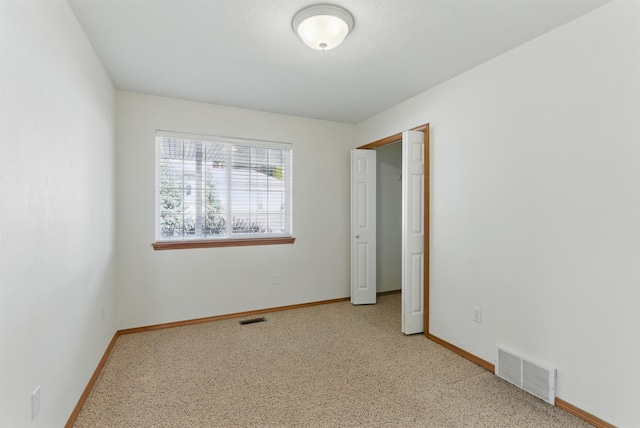 unfurnished bedroom with light carpet, visible vents, and baseboards