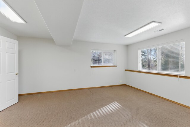 carpeted empty room featuring visible vents and baseboards