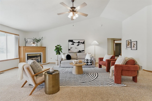 carpeted living area featuring vaulted ceiling, ceiling fan, a glass covered fireplace, and baseboards