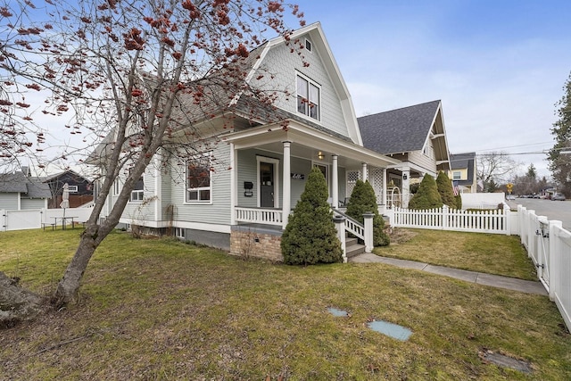 603 N 7th St, Coeur D Alene, ID 83814 - view of front of house with a front yard, a porch, a fenced backyard, a gambrel roof, and a shingled roof