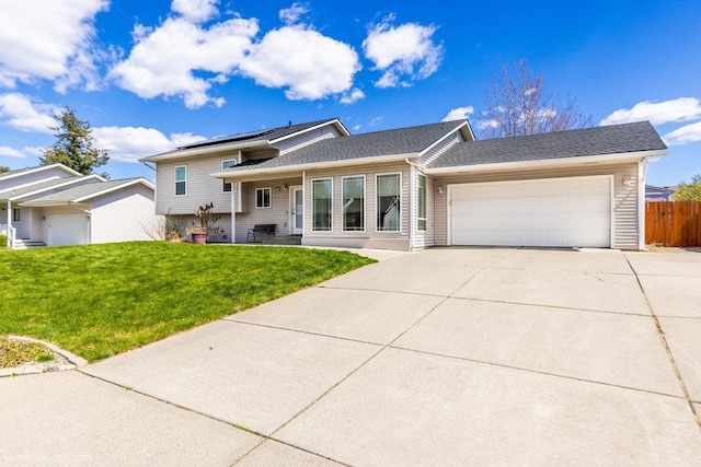 510 N Bell St, Spokane Valley, WA 99016 - split level home featuring fence, a front lawn, solar panels, an attached garage, and driveway