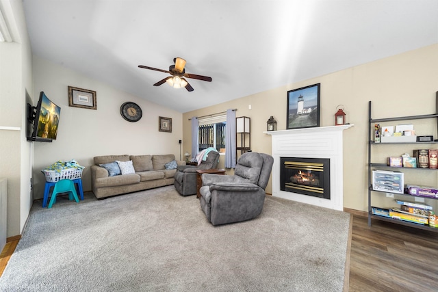 living room featuring lofted ceiling, ceiling fan, wood finished floors, and a glass covered fireplace