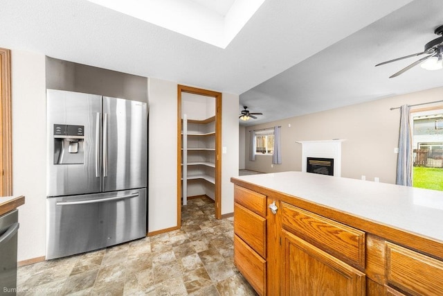 510 N Bell St, Spokane Valley, WA 99016 - kitchen featuring light countertops, baseboards, stainless steel fridge, a glass covered fireplace, and ceiling fan