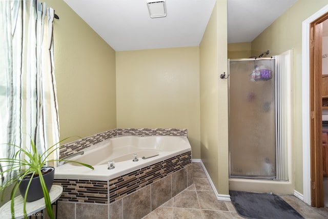 bathroom featuring tile patterned flooring, a shower stall, baseboards, and a bath