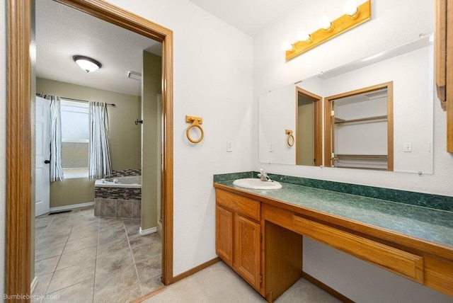510 N Bell St, Spokane Valley, WA 99016 - bathroom featuring baseboards, tile patterned floors, vanity, and a relaxing tiled tub
