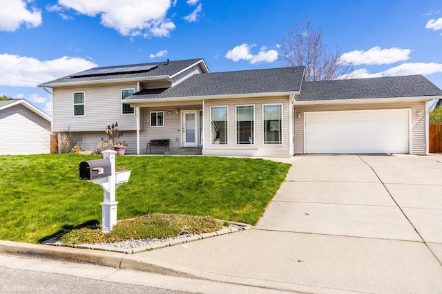 510 N Bell St, Spokane Valley, WA 99016 - tri-level home featuring roof with shingles, solar panels, concrete driveway, a garage, and a front yard