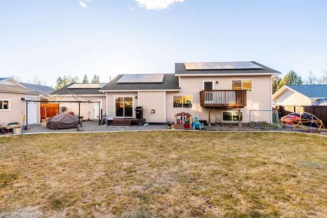 back of house with solar panels, a lawn, a gazebo, a patio area, and fence