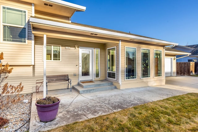 rear view of property with entry steps, a patio area, and fence