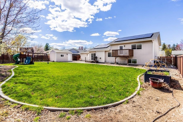 510 N Bell St, Spokane Valley, WA 99016 - rear view of house with a garden, an outbuilding, a fenced backyard, a playground, and roof mounted solar panels